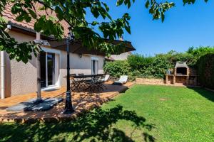 Un patio con una mesa y sillas en un patio. en Charmante Maison Climatisée avec son Jardin à 5 minutes de DIJON, en Saint-Apollinaire