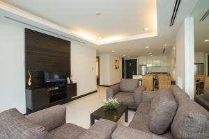 a living room with couches and a flat screen tv at The Palms, Kamala Beach - SHA Extra Plus in Kamala Beach