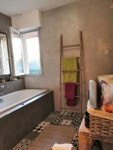 a bathroom with a tub and a television in it at B&B Egloff in Eaucourt-sur-Somme