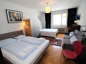 ein Hotelzimmer mit 2 Betten und einem Sofa in der Unterkunft Apartment Opera by Interhome in Wien