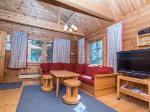 a living room with a red couch and a flat screen tv at Holiday Home Uolevintie 39a by Interhome in Ruka