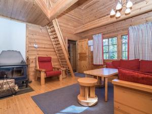 a living room with a fireplace in a log cabin at Holiday Home Uolevintie 39a by Interhome in Ruka