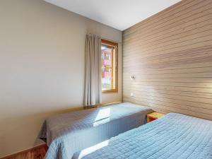 a bedroom with two beds and a window at Holiday Home Aurinkoranta by Interhome in Ruka