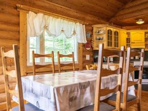 a dining room with a table and chairs in a cabin at Holiday Home Sarvitupa by Interhome in Kangashäkki