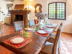 a dining room with a wooden table and a fireplace at Holiday Home La Réalière by Interhome in Beaumettes