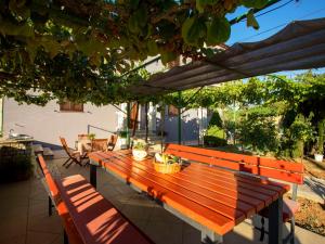 a wooden bench sitting under a pergola at Apartment Olivia by Interhome in Pićan