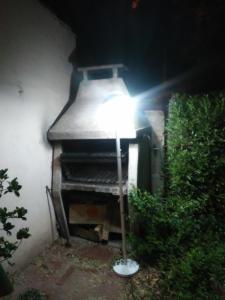 una lámpara sentada frente a un horno de ladrillo en Vivienda en altos con uso exclusivo de entrada de auto y parrilla en Miramar