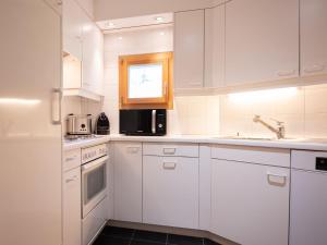 uma cozinha branca com armários brancos e uma janela em Apartment Chesa Cresta by Interhome em Surlej