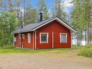 uma pequena casa vermelha com um telhado preto em Holiday Home Lepokunnas by Interhome em Suomussalmi