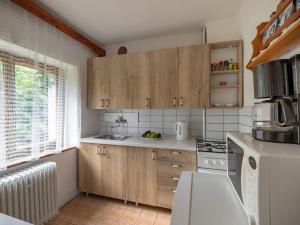 uma cozinha com armários de madeira e um frigorífico branco em Holiday Home Jestřebice 8 by Interhome em Dobřeň