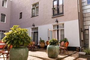 twee grote vazen met planten voor een gebouw bij Ambassador City Centre Hotel in Haarlem