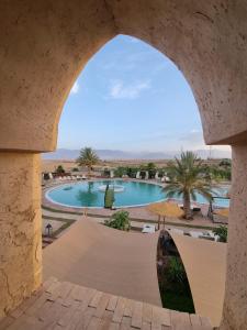 - une vue sur la piscine depuis une arche dans l'établissement Les Jardins d Amizmiz, à Marrakech
