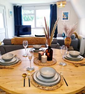 a dining room table with plates and wine glasses at 19 the Coombe in Bude