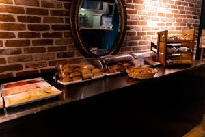 a counter with various types of bread and a mirror at Ambassador City Centre Hotel in Haarlem