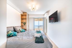 1 dormitorio con 1 cama grande y TV de pantalla plana en Baie de Monaco, Vue Mer, Terrasse, Parking Gratuit - AF en Beausoleil