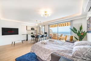 a bedroom with a bed and a living room and a kitchen at Baie de Monaco, Vue Mer, Terrasse, Parking Gratuit - AF in Beausoleil