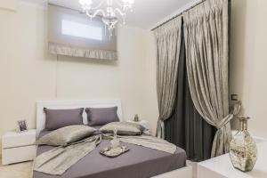 a bedroom with a bed and a chandelier at Danae Luxury Apartment in Samos
