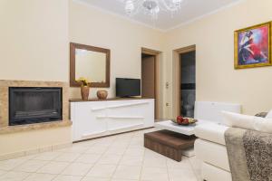 a living room with a couch and a tv at Danae Luxury Apartment in Samos