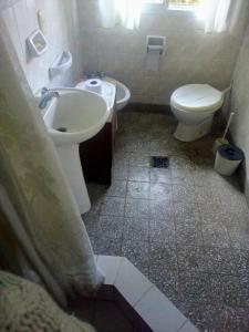 y baño con aseo blanco y lavamanos. en Vivienda en altos con uso exclusivo de entrada de auto y parrilla en Miramar