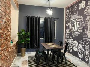 a dining room with a table and black chairs at The Berlian Guesthouse - Two beedroom Apartment with Pool View in Port Dickson