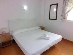 Schlafzimmer mit einem weißen Bett und einem Spiegel in der Unterkunft apartamento 46A VORA 2 dormitorio in Calpe