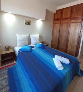 een slaapkamer met een blauw bed en handdoeken bij Les Jardins d Amizmiz in Marrakesh