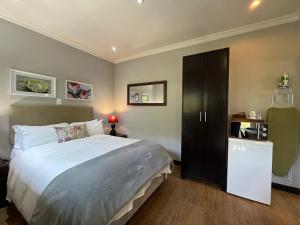 a bedroom with a large bed and a black cabinet at ilanda Guest House in White River