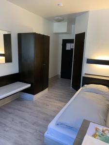 um quarto com uma cama e um armário e uma cama e uma cama em City Hotel Dinslaken em Dinslaken