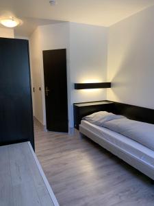 1 dormitorio con cama y puerta negra en City Hotel Dinslaken, en Dinslaken