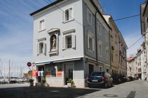a white building with a car parked in front of it at PortHouse Apartments in Piran