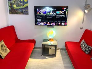 ロスピタレート・デ・リョブレガートにあるCamp Nou, Europa Fira - modern two-bedroom apartment with heatingのリビングルーム(赤い椅子2脚、薄型テレビ付)