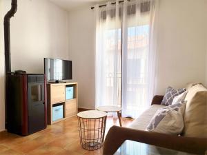 een woonkamer met een bank en een tv bij Casa en el valle del tietar in Lanzahita