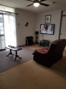 un soggiorno con un divano, un tavolo e una TV di Bayside Home-Now Backpacker's price in Kingscote Esplanade in Buller a Kingscote