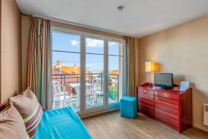 Pokój z łóżkiem, telewizorem i balkonem w obiekcie Residence Pierre & Vacances Port Guillaume w mieście Dives-sur-Mer