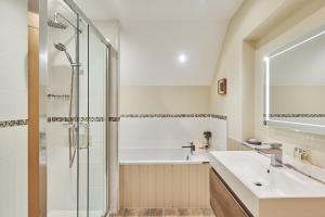 a bathroom with a shower and a sink and a tub at The Lansdowne Guest House in Bourton on the Water