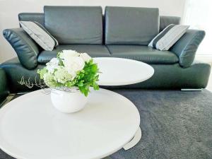 a living room with two white tables and a couch at Dünenresidenz Königin Augusta - Apt. 11 in Binz