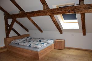 Mislinja的住宿－Valle Divina，卧室配有一张床铺,位于带木梁的房间