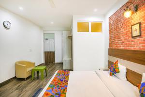 een slaapkamer met een bed en een bakstenen muur bij FabHotel Aravali Suites in Gurgaon