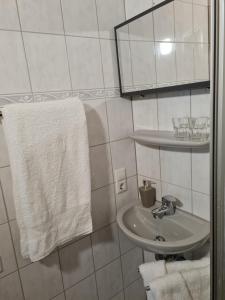 a bathroom with a sink and a mirror and towels at Zum Goldenen Fass in Nassau