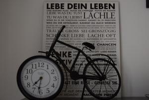 a clock on a wall next to a poster of a bicycle at Auszeit by Kirschner in Mönchhof