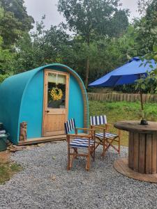 a blue dome tent with two chairs and a table at Gower Pods in Penclawdd