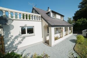 una casa independiente con una extensión del techo y un patio en Ballygown Cottage en Torpys Cross Roads