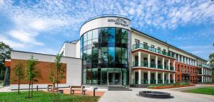 a building with a glass facade on a street at Mineral SPA Draugystė in Druskininkai