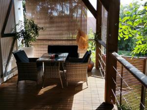 un patio con tavolo e sedie sul balcone. di Les sens ciels a Saint-Louis