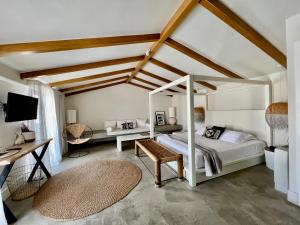 Kefalonia Grand في أرغوستولي: غرفة نوم مع سرير المظلة ومكتب