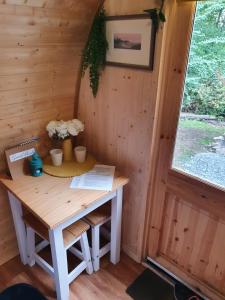 una mesa pequeña en una cabaña con ventana en Gower Pods en Penclawdd