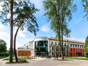 an office building with trees in front of it at Mineral SPA Draugystė in Druskininkai