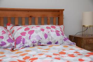 a bed with two pillows on it with at Stylish one bed apartment in the Stroud Valleys in Brimscombe