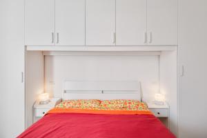 una camera con letto rosso e armadi bianchi di Corte Agordat Apartment x4 - Pet Friendly a Padova