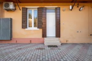 ein Gebäude mit einer weißen Tür und einem Fenster in der Unterkunft Corte Agordat Apartment x4 - Pet Friendly in Padua